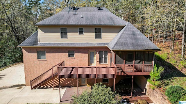 back of house featuring a sunroom, a patio area, and a wooden deck