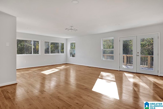 empty room featuring ceiling fan, light wood-type flooring, and french doors