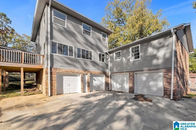 rear view of property with a deck and a garage