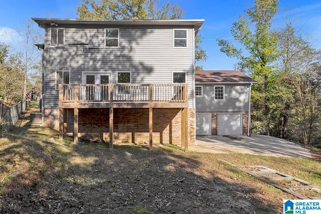 back of house with a garage and a deck