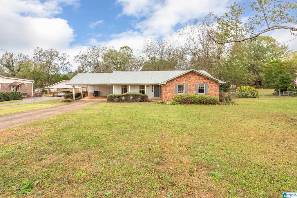 ranch-style home featuring a carport and a front lawn