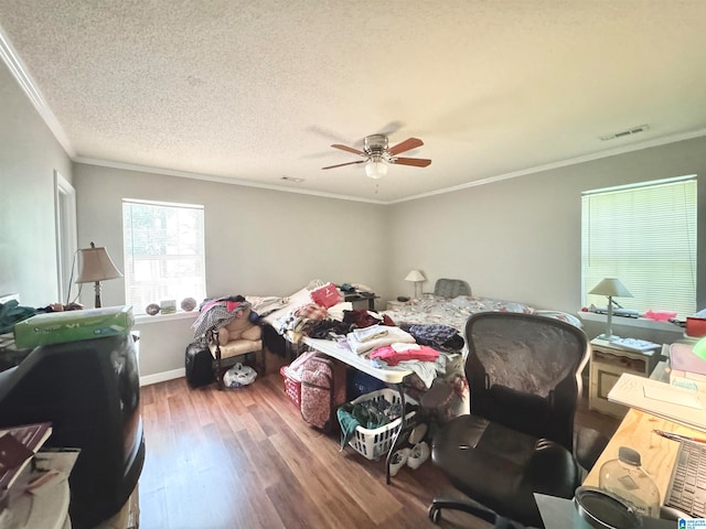 bedroom with wood-type flooring, a textured ceiling, ceiling fan, and crown molding