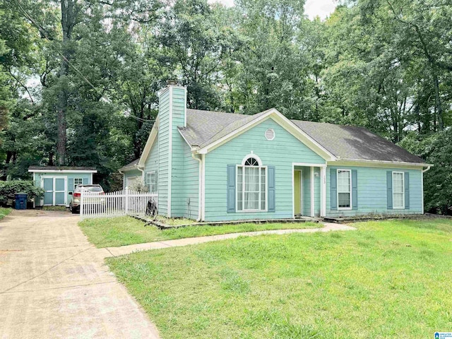 view of front of house with a shed and a front lawn