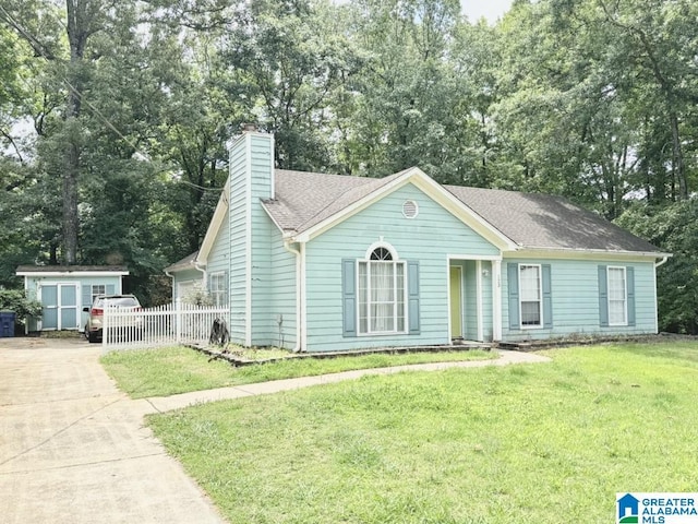 view of front of home featuring a front lawn and a storage unit