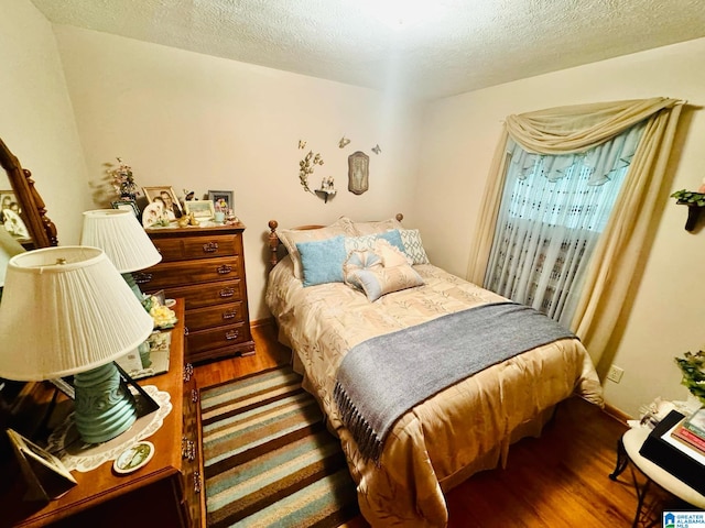 bedroom featuring wood-type flooring and a textured ceiling