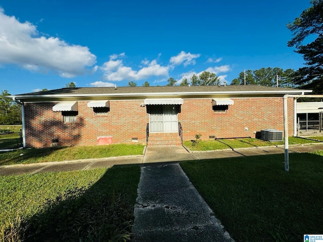 exterior space featuring cooling unit and a front yard