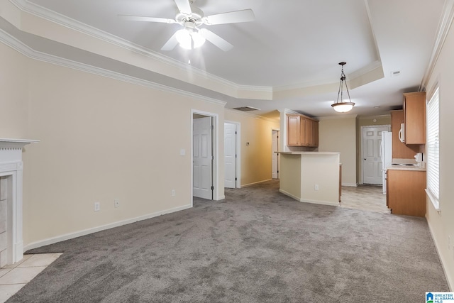 unfurnished living room with light colored carpet, a raised ceiling, and ornamental molding