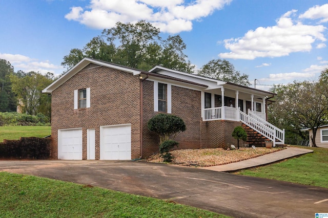 view of side of home with covered porch, a garage, and a lawn