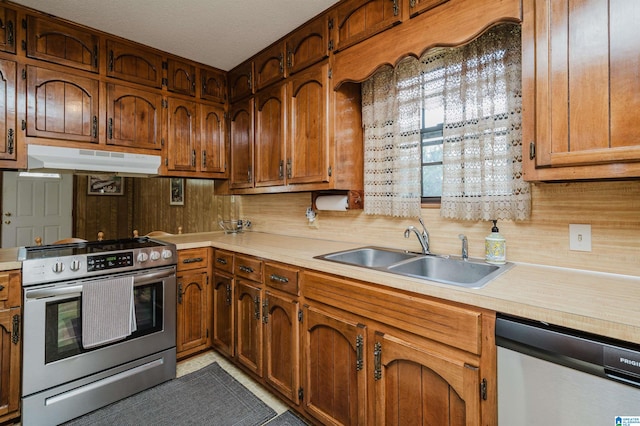 kitchen with a textured ceiling, sink, and stainless steel appliances