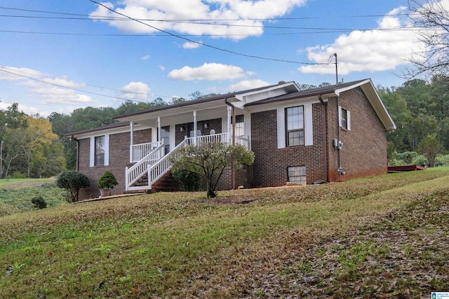 ranch-style house with covered porch and a front yard