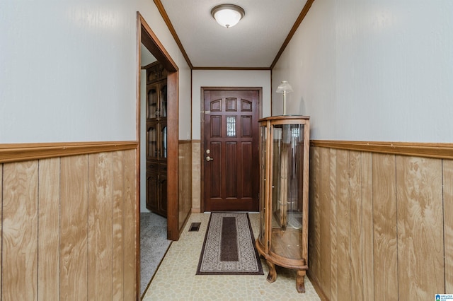 entryway with wooden walls and crown molding