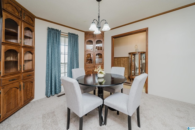 dining area featuring light carpet, crown molding, a chandelier, and wooden walls