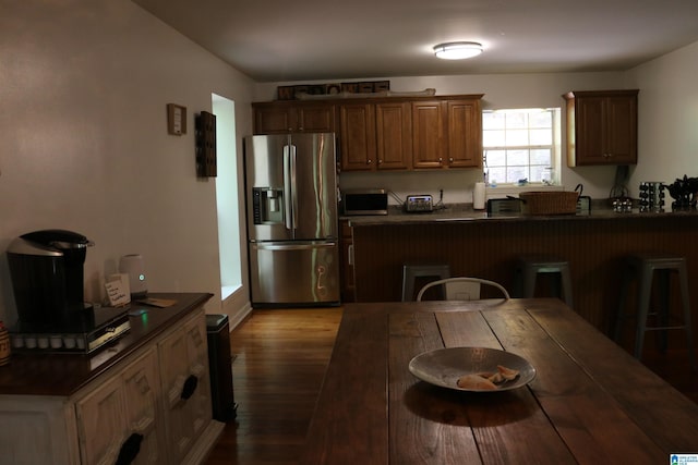 551 Poplar Pl, Wedowee, AL 36278 - kitchen featuring stainless steel appliances, dark countertops, wood finished floors, a kitchen bar, and a peninsula