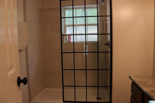 bathroom featuring a tile shower and vanity