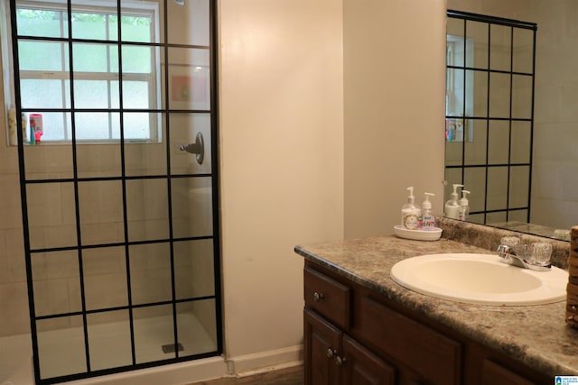 bathroom featuring a tile shower, vanity, and hardwood / wood-style flooring