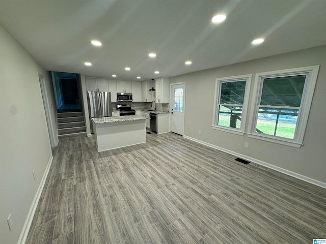 kitchen featuring white cabinets, appliances with stainless steel finishes, light hardwood / wood-style flooring, and plenty of natural light