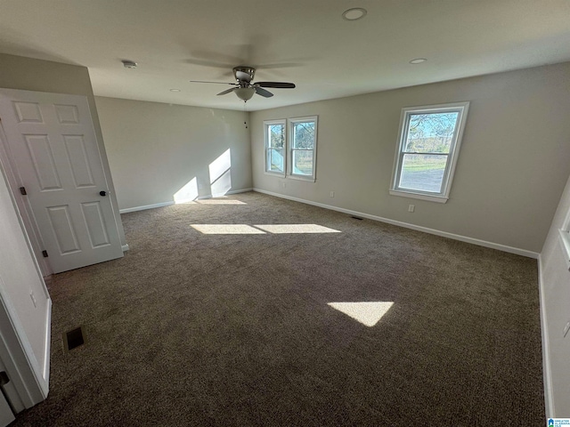 carpeted empty room with a wealth of natural light and ceiling fan