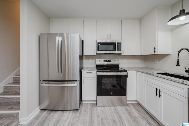 kitchen featuring sink, white cabinets, light hardwood / wood-style flooring, and appliances with stainless steel finishes