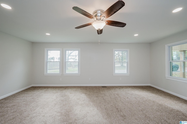 carpeted spare room with plenty of natural light and ceiling fan