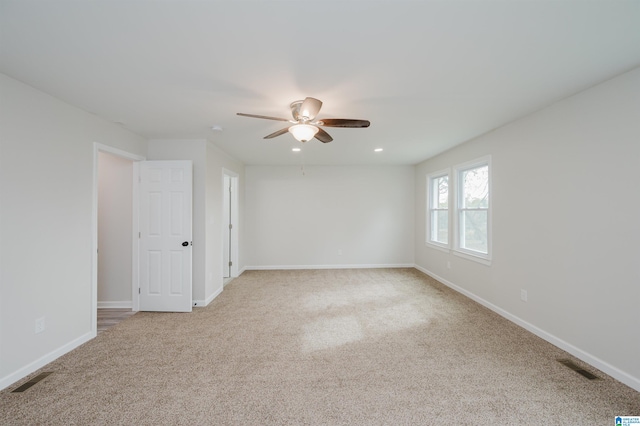 unfurnished room with ceiling fan and light carpet