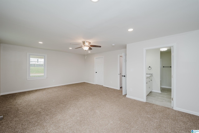 spare room featuring ceiling fan and light colored carpet