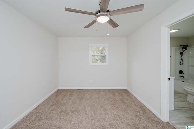 carpeted spare room featuring ceiling fan