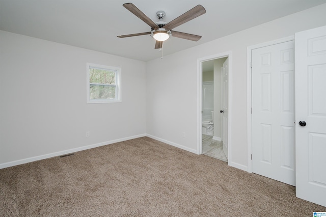 unfurnished bedroom with carpet flooring, ceiling fan, and ensuite bathroom