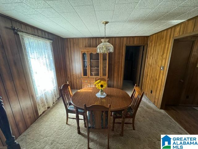 dining space featuring wood walls