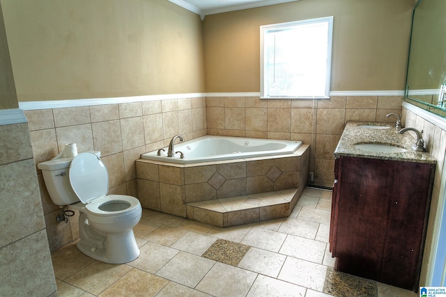 bathroom featuring vanity, a relaxing tiled tub, toilet, ornamental molding, and tile walls