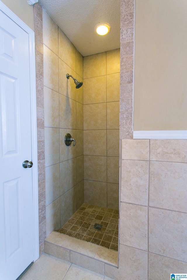 bathroom featuring a tile shower and a textured ceiling