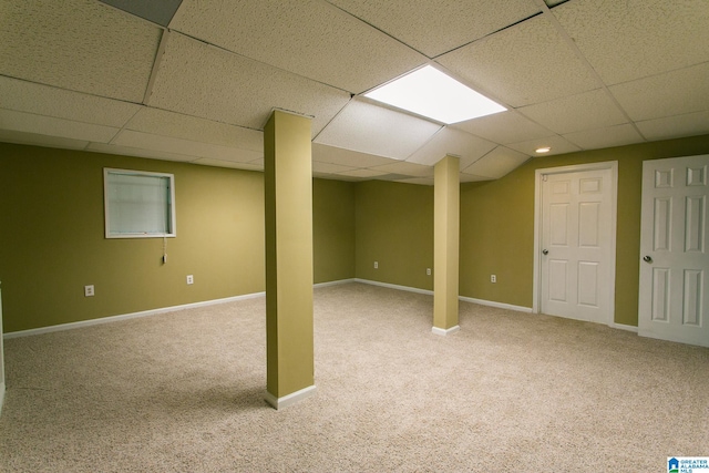 basement featuring a drop ceiling and light carpet