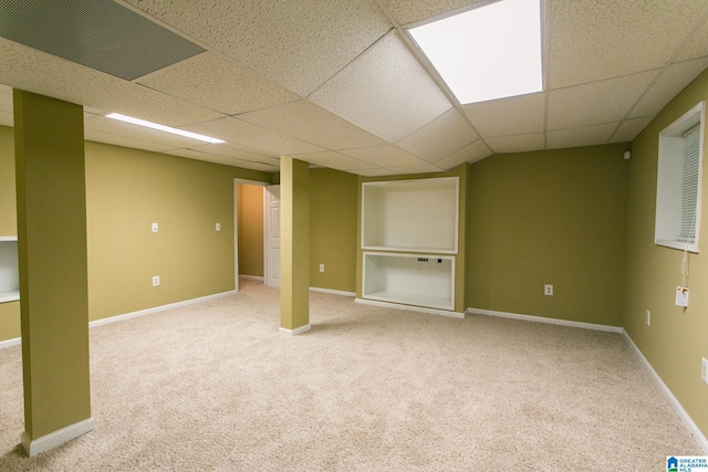 basement featuring carpet and a drop ceiling