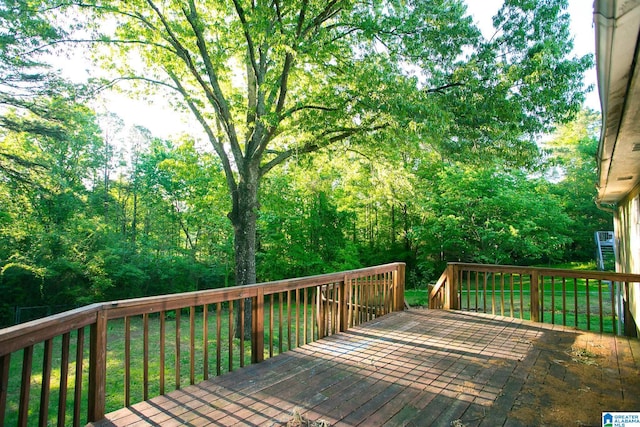 wooden deck featuring a lawn