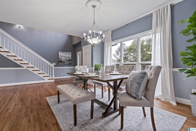 dining room with dark wood-type flooring and a chandelier