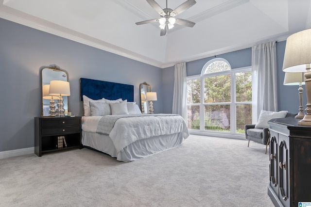 carpeted bedroom featuring a raised ceiling, ceiling fan, and crown molding