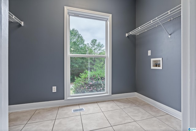 clothes washing area featuring washer hookup and light tile patterned floors