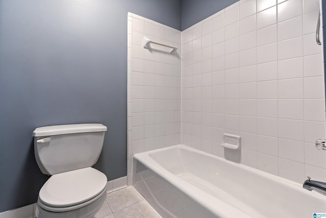 bathroom with tile patterned flooring, toilet, and tiled shower / bath