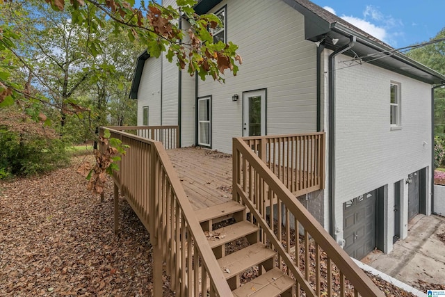 back of property featuring a garage and a wooden deck