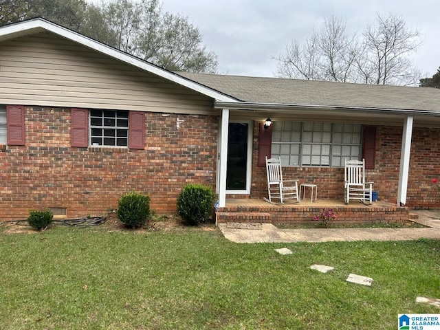 ranch-style house featuring a front yard and covered porch