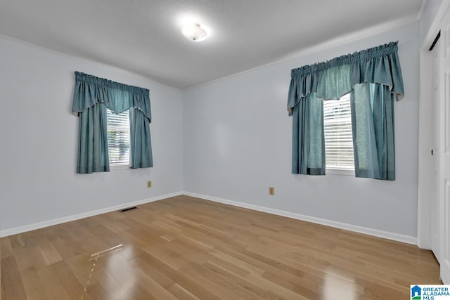 spare room with hardwood / wood-style flooring and ornamental molding