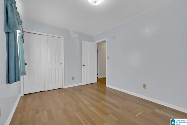 unfurnished bedroom with a closet and light wood-type flooring