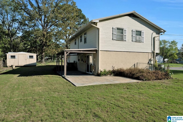 rear view of house featuring a lawn, a storage unit, and a patio