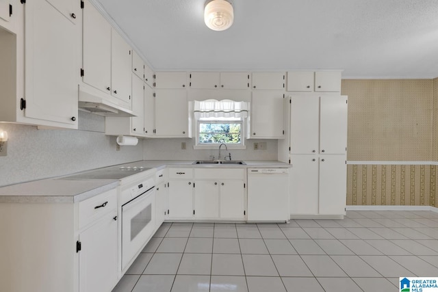 kitchen with white cabinetry, dishwasher, sink, cooktop, and light tile patterned floors