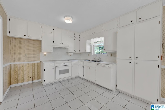 kitchen featuring light tile patterned floors, white appliances, white cabinetry, and sink