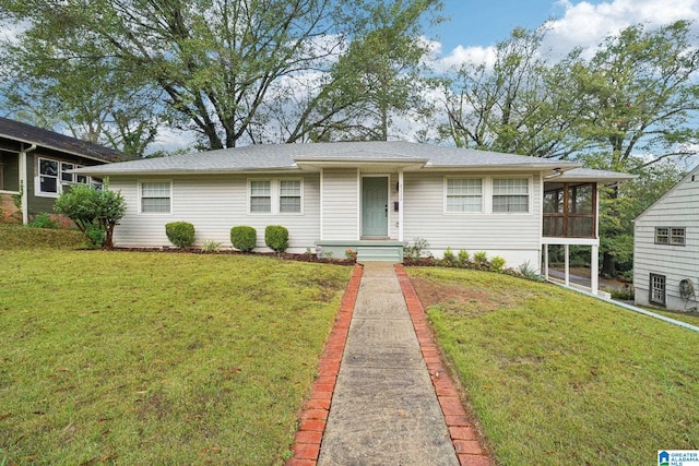 single story home featuring a front yard and a sunroom