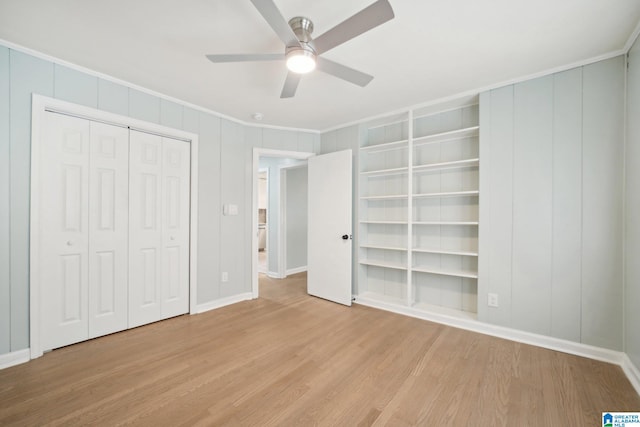 unfurnished bedroom with ceiling fan, light wood-type flooring, crown molding, and a closet