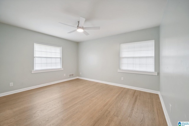 empty room with ceiling fan and light hardwood / wood-style floors