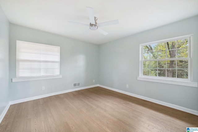 empty room with ceiling fan and light hardwood / wood-style flooring