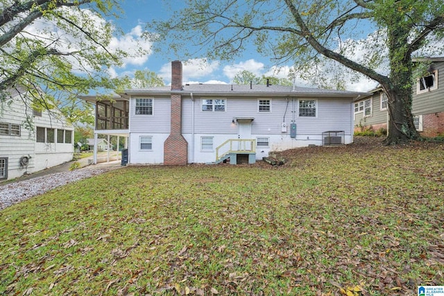 back of house with a lawn and a sunroom