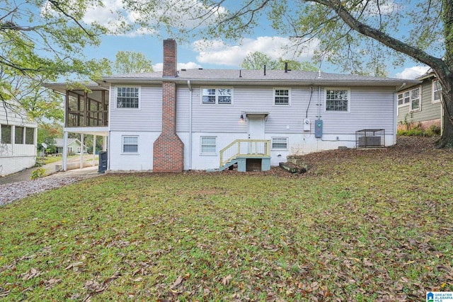 back of house featuring a sunroom, central AC, and a lawn